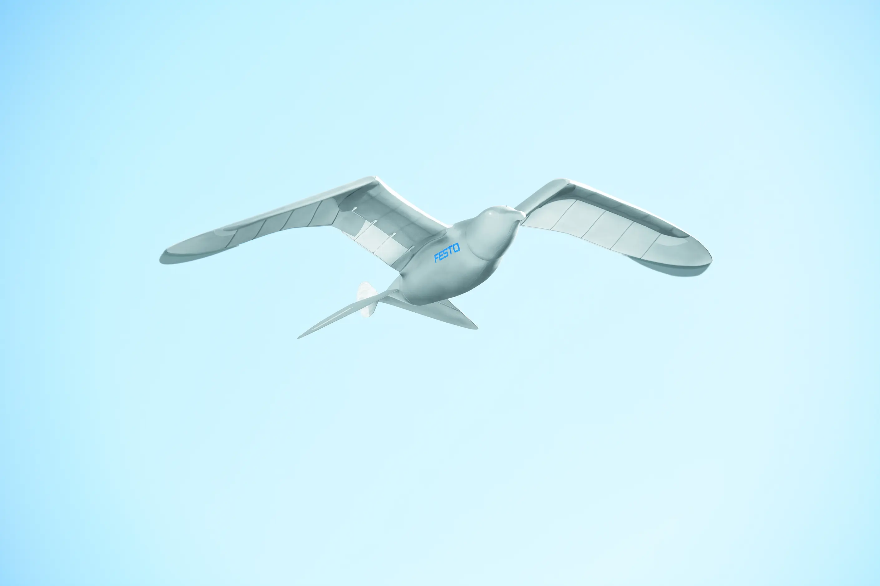 Festo SmartBird robot in flight against a pale sky, wings spread like a herring gull
