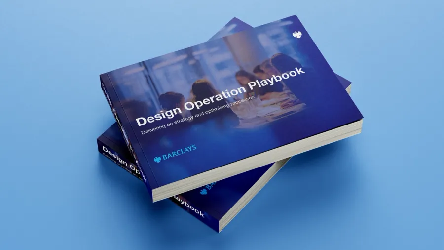 Two copies of the Barclays Design Operation Playbook stacked on a blue ground, the cover reading Delivering on strategy and optimising processes.