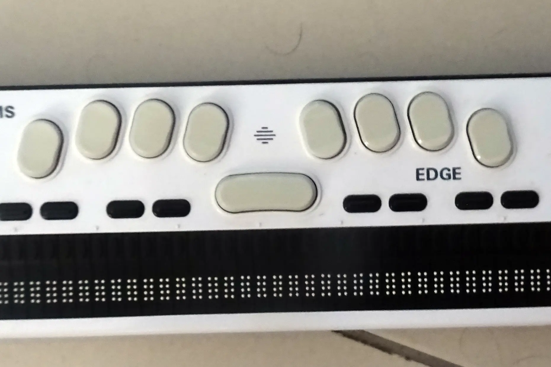 Refreshable braille display with a row of raised pin cells beneath its navigation keys