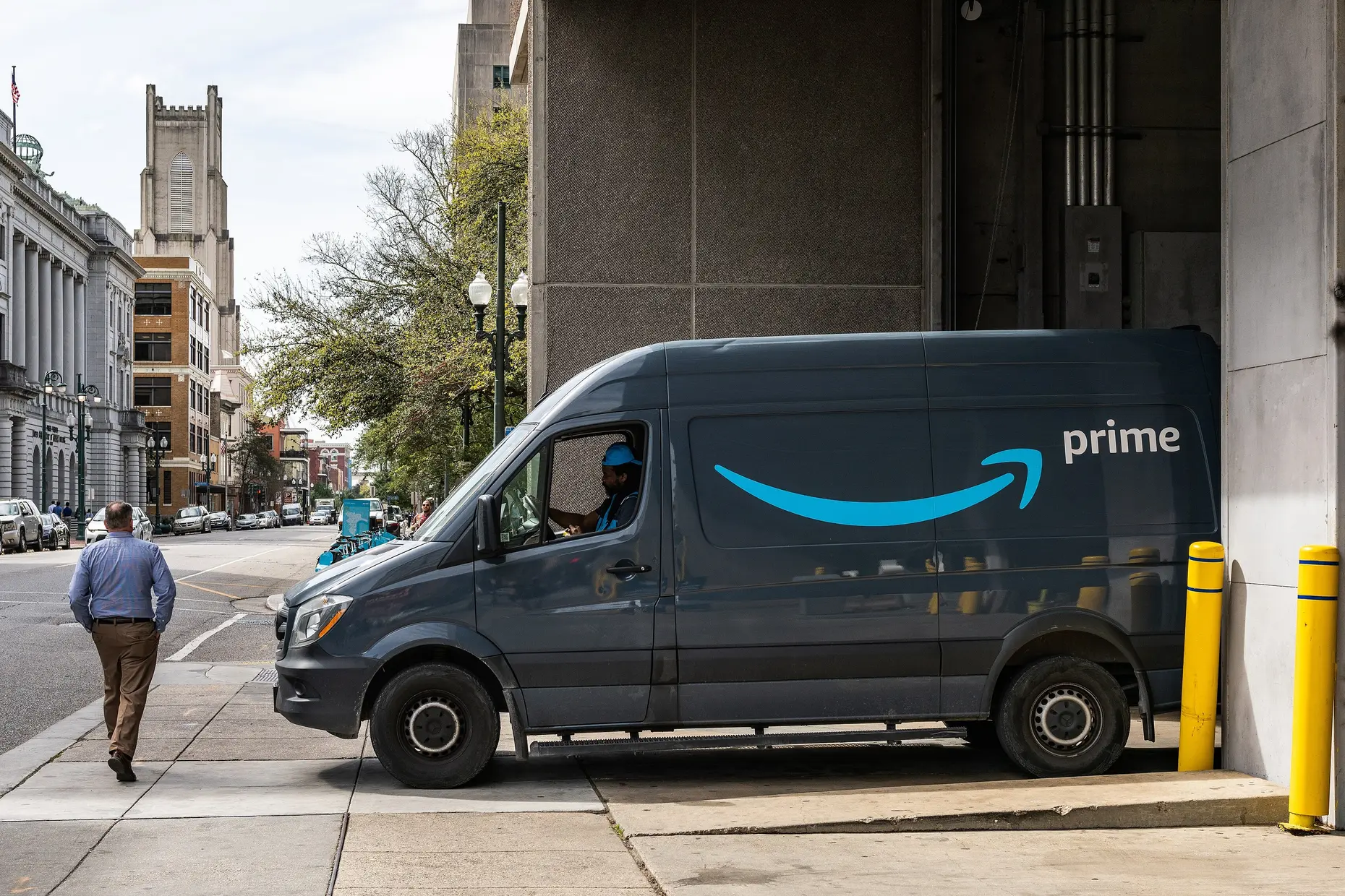 An Amazon Prime delivery van parked on a city street, same day delivery scaled into a logistics network.