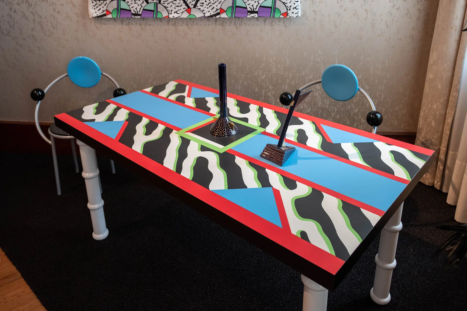 Terrazzo pattern dining table in black white blue and red with matching tubular chairs