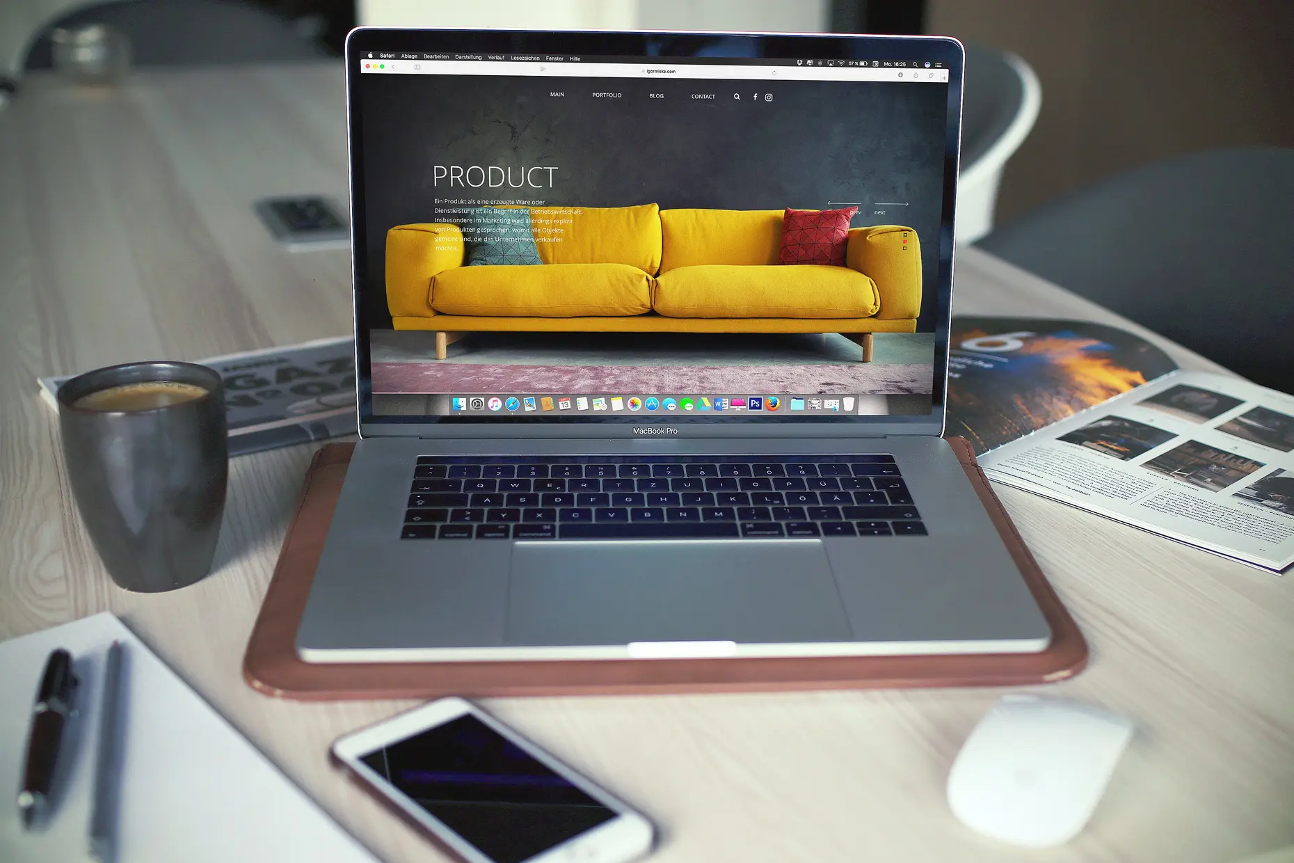 A laptop showing a furniture product page on a desk, a smartphone lying face up beside it