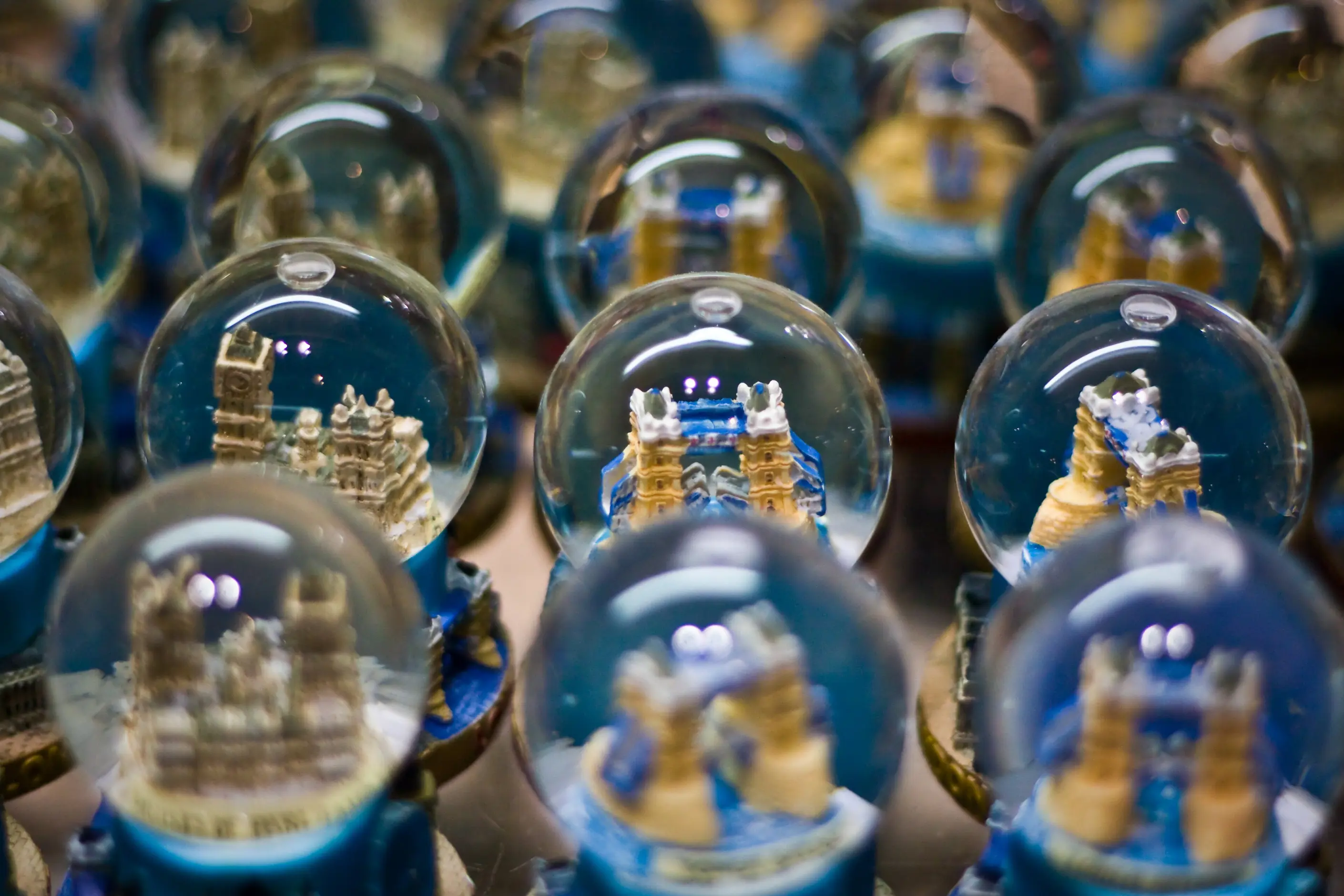 Rows of identical snow globes each containing a miniature London landmark