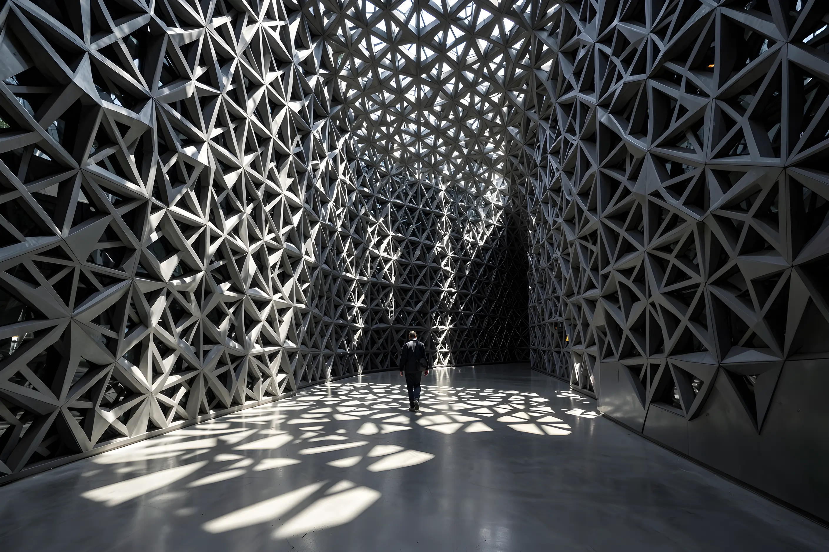 Sunlight through a contemporary star-patterned lattice casting star-shaped shadows across a concrete atrium floor