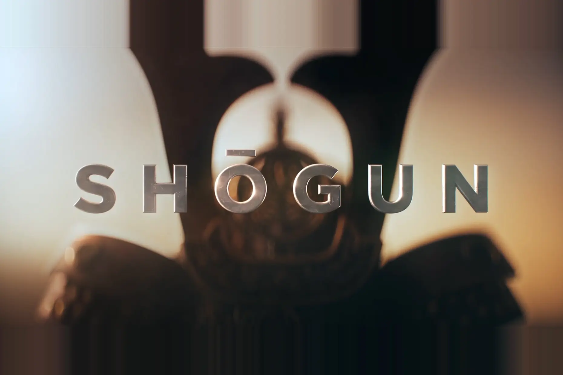 Brushed metal title lettering spelling Shōgun over a blurred samurai helmet