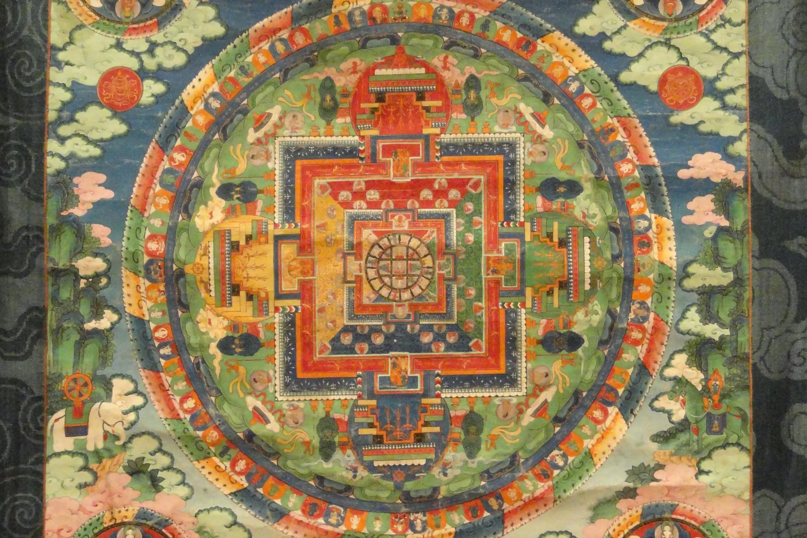 A square Kalachakra mandala with concentric rings painted in red, gold and blue
