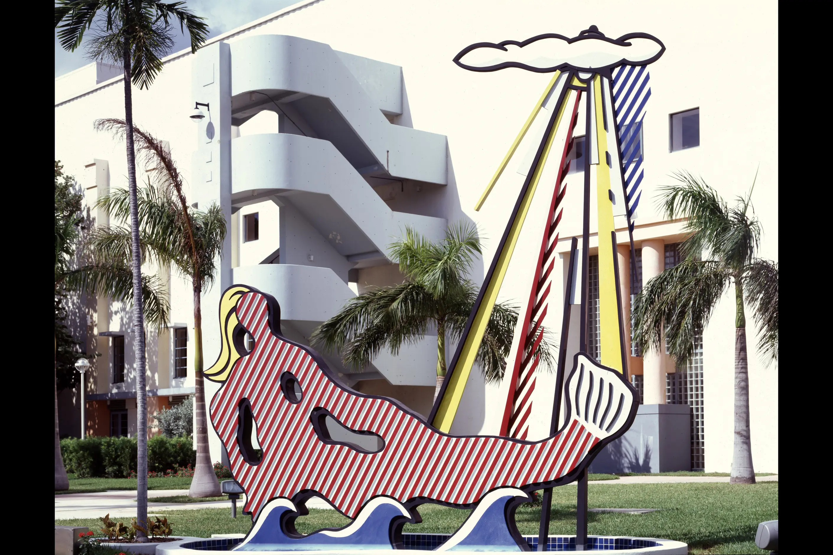 Lichtenstein's Mermaid sculpture: a striped pink figure in waves beneath a palm tree, Miami Beach