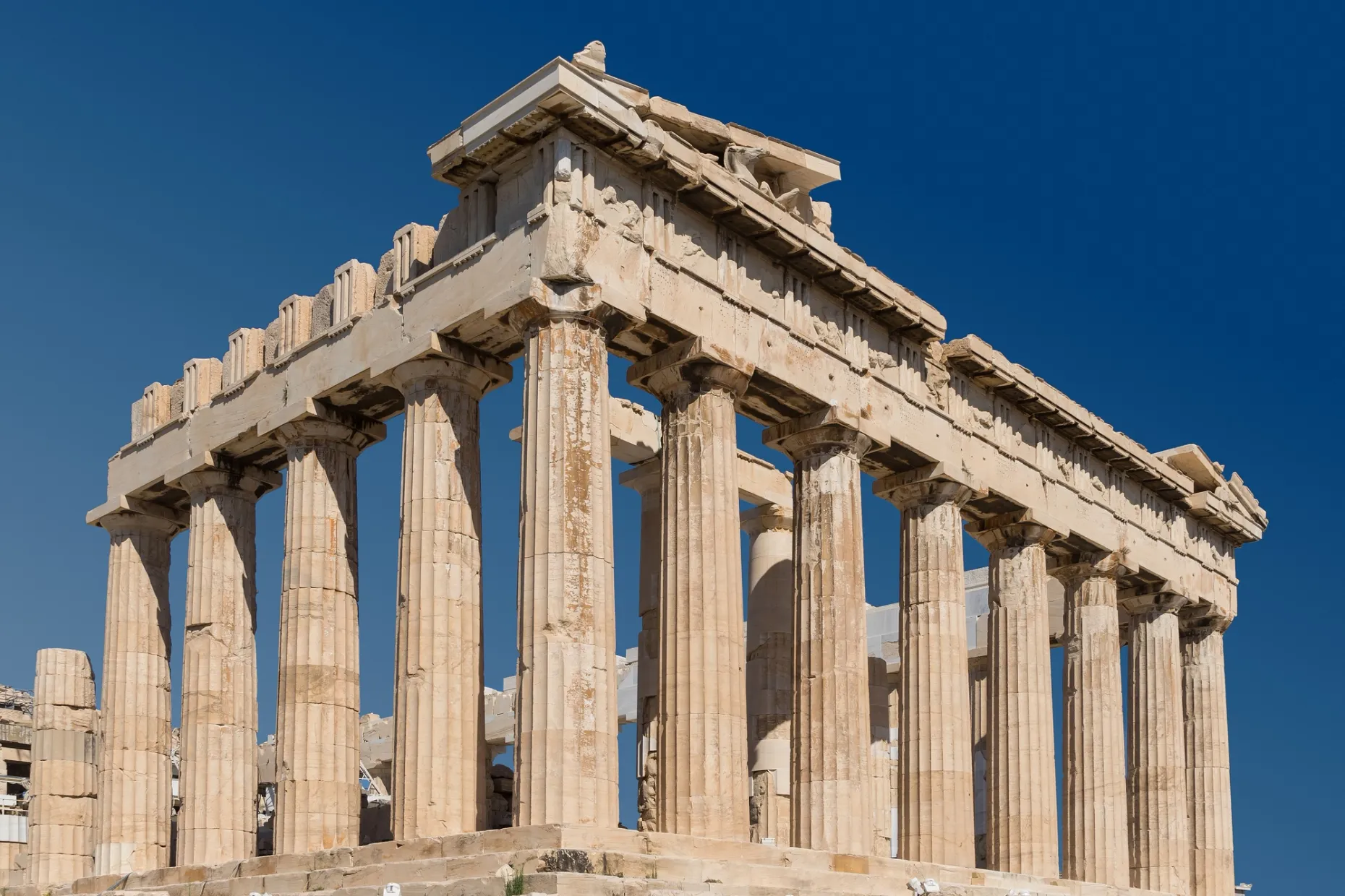 The Parthenon's weathered marble columns and pediment against a clear blue sky