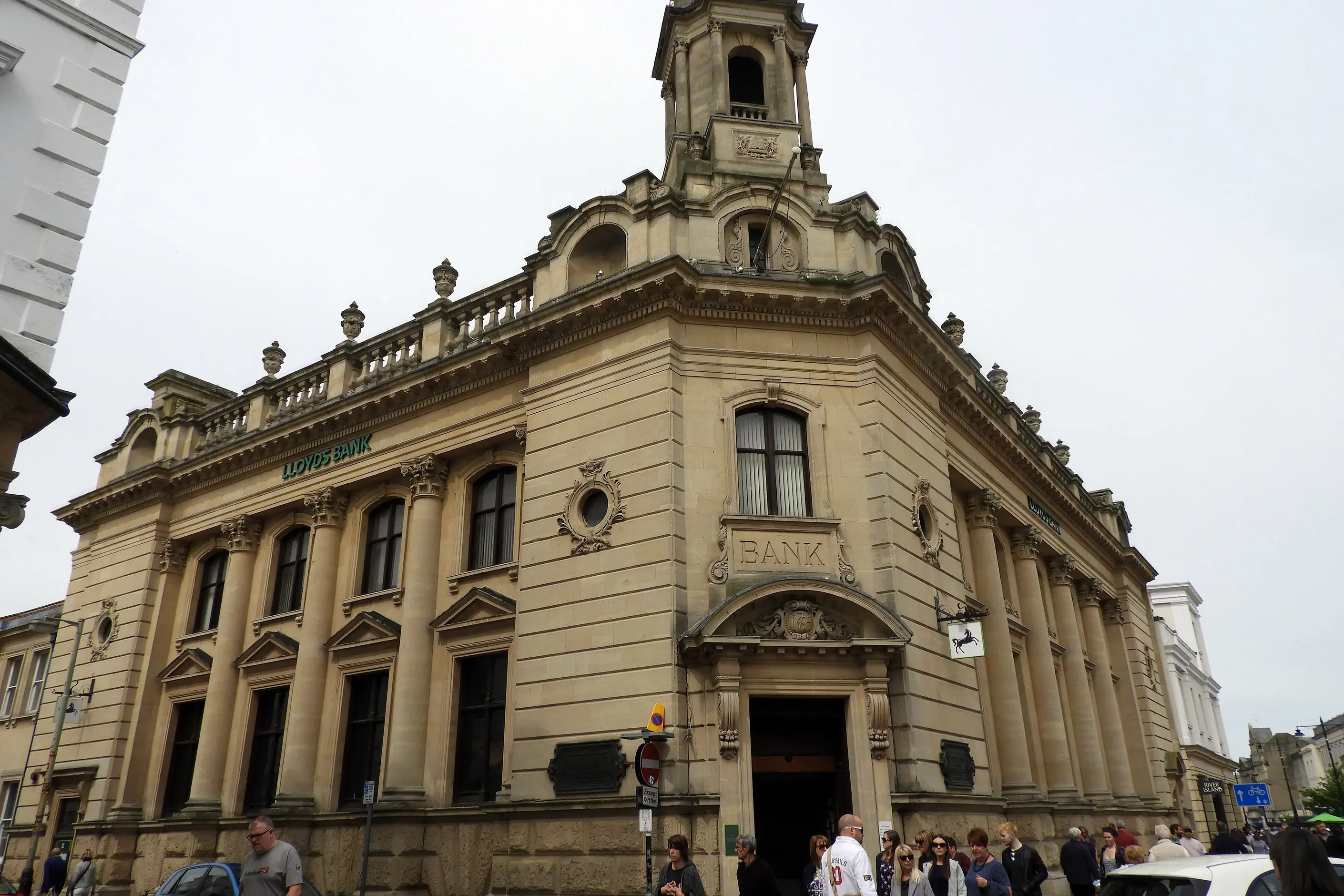 A grand stone bank branch building with its name above the entrance