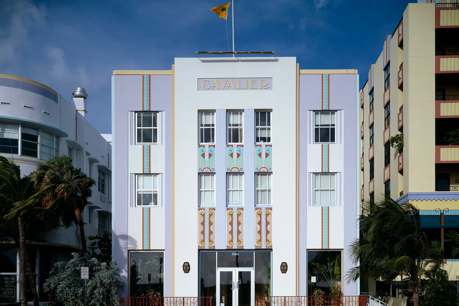 The Cavalier Hotel's symmetrical white facade with vertical bands and stepped geometric panels in pastel