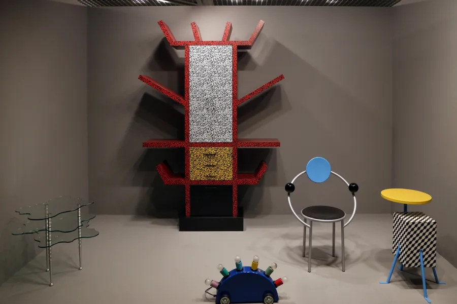 Sottsass Carlton Bookcase in red terrazzo laminate beside other Memphis Group furniture
