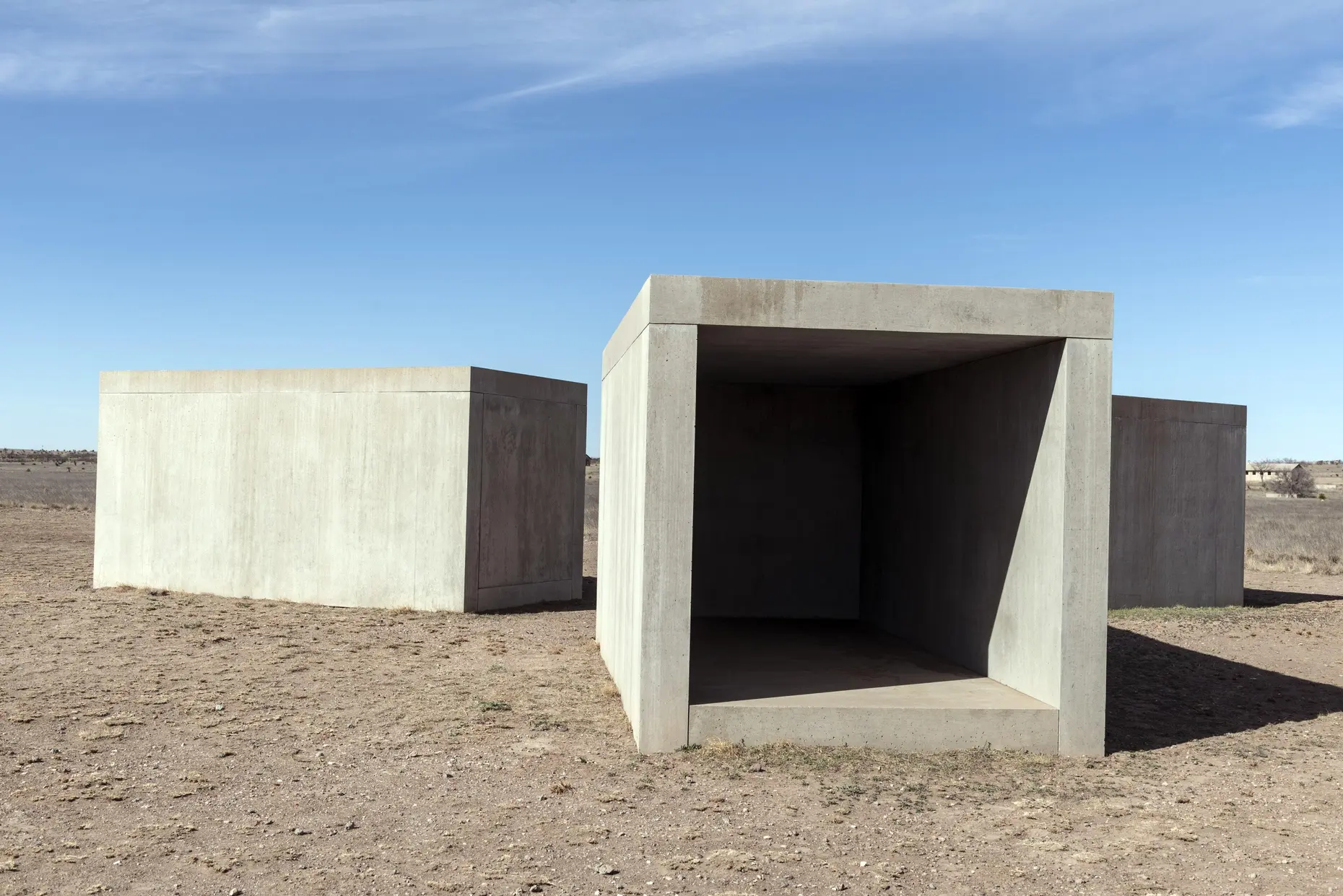 Large hollow concrete rectangular boxes spaced across an open desert landscape