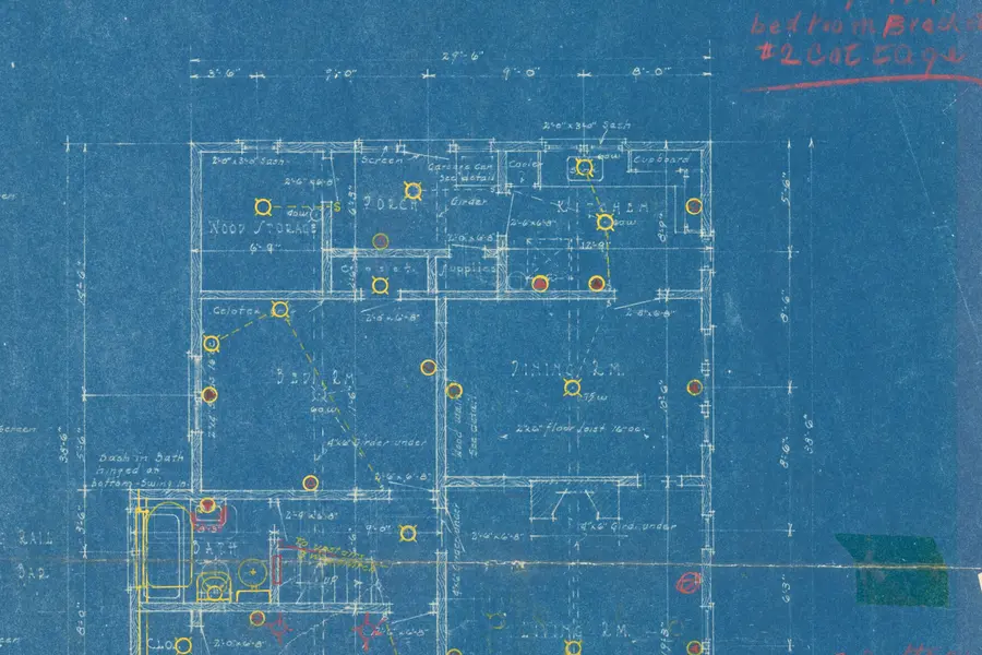 A faded cyanotype floor plan with white linework, dimensions and room labels, marked up in yellow and red by hand